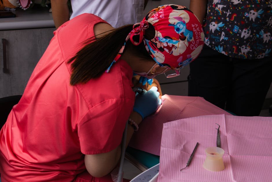 A dentist in vibrant scrubs focuses intently on a dental procedure.