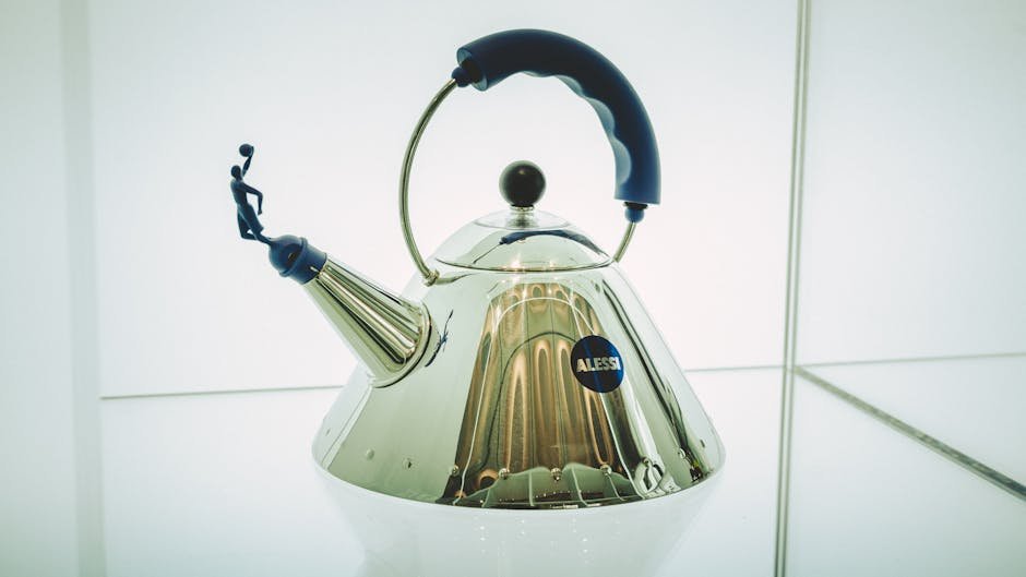 Close-up of a sleek Alessi kettle featuring a unique blue handle design.