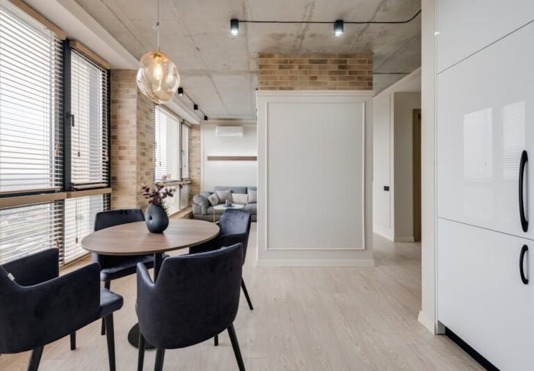 Elegant modern living room with a dining table, chairs, and stylish decor in a bright setting.
