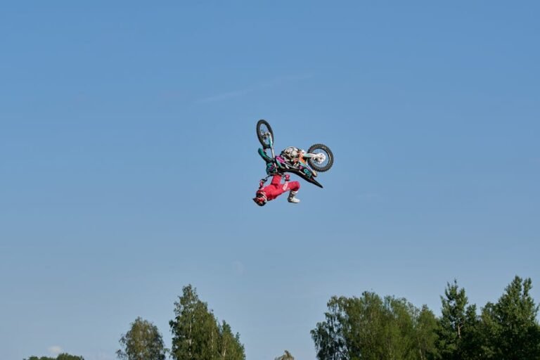 Daring motocross stunt against a clear blue sky, showcasing extreme sports excellence.