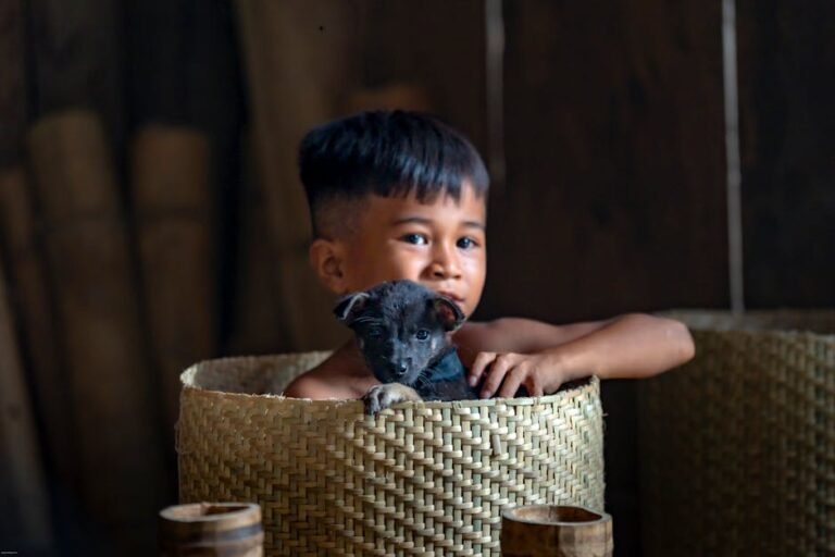 Young boy with a puppy in a wicker basket inside a cozy setting.