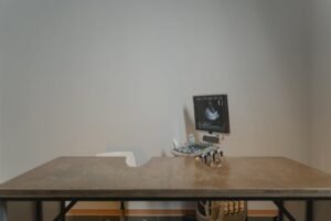 Ultrasound machine setup in a minimalist medical office for patient examinations.