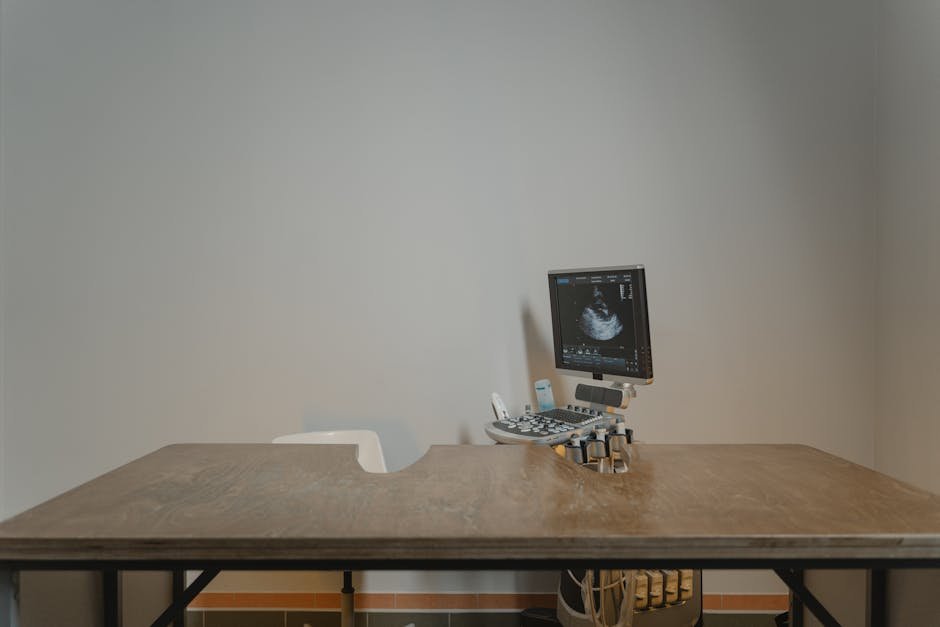 Ultrasound machine setup in a minimalist medical office for patient examinations.