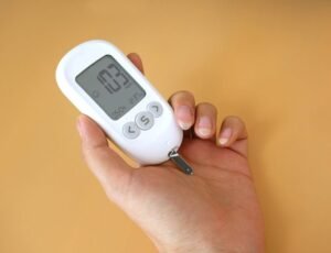 Close-up view of a blood glucose meter in hand measuring glucose levels.