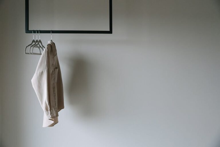 A beige blazer hangs on a minimalist metal rack, providing a serene and stylish wardrobe aesthetic.